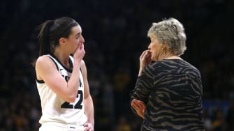 Iowa’s Caitlin Clark (22) talks to coach Lisa Bluder