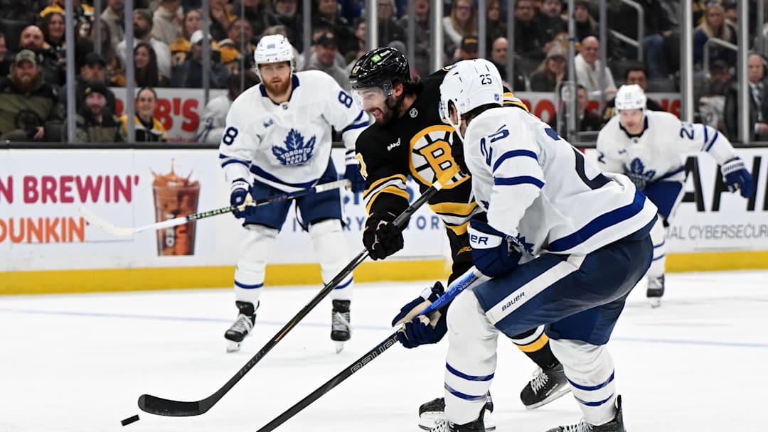 Nov 11, 2025; Boston, Massachusetts, USA; Boston Bruins center Mark Kastelic (47) controls the puck against Toronto Maple Leafs defenseman Brandon Carlo (25) during the third period at the TD Garden. Mandatory Credit: Brian Fluharty-Imagn Images