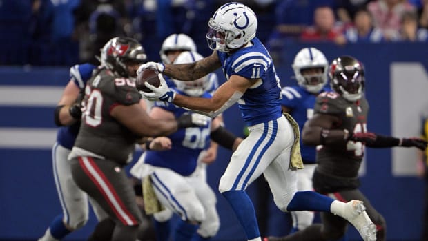 Colts receiver Michael Pittman Jr. (blue jersey with white pants/helmet) makes a catch across the football field. 