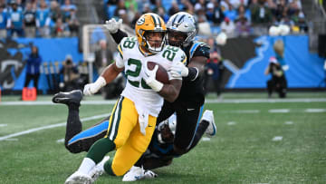 Dec 24, 2023; Charlotte, North Carolina, USA; Green Bay Packers running back AJ Dillon (28) with the ball as Carolina Panthers defensive tackle DeShawn Williams (96) and linebacker Brian Burns (0) defend in the fourth quarter at Bank of America Stadium.