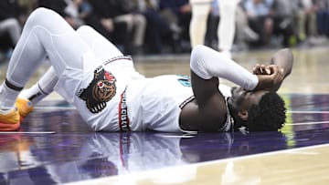 Apr 8, 2025; Charlotte, North Carolina, USA;  Memphis Grizzlies center Jaren Jackson Jr. (13) lays on the floor briefly after falling hard during the second half against the Charlotte Hornets at the Spectrum Center. Mandatory Credit: Sam Sharpe-Imagn Images