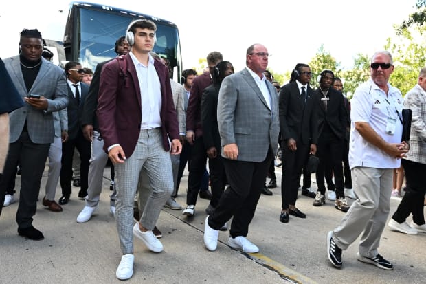 Texas A&M Aggies quarterback Conner Weigman, left, and head coach Mike Elko, right, arrive prior to a game.