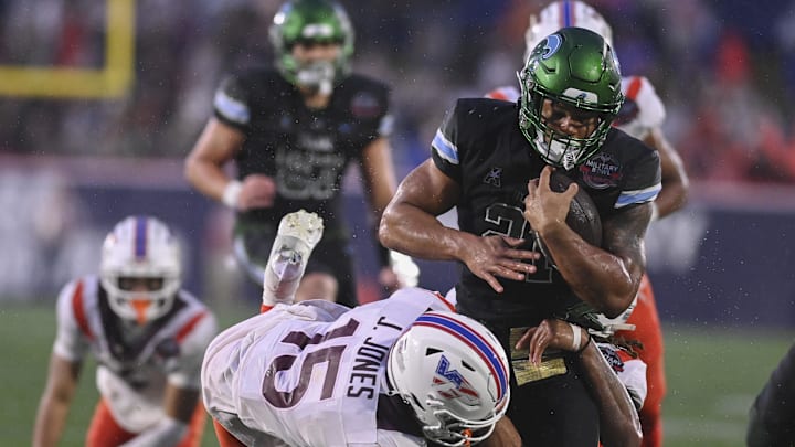 Dec 27, 2023; Annapolis, MD, USA; Tulane Green Wave running back Makhi Hughes (21) rushes as Virginia Tech Hokies safety Jaylen Jones (15) attempts to tackle during the third quarter at Navy-Marine Corps Memorial Stadium. Dec 27, 2023; Annapolis, MD, USA; Tulane Green Wave running back Makhi Hughes (21) rushes as Virginia Tech Hokies safety Jaylen Jones (15) attempts to tackle during the third quarter at Navy-Marine Corps Memorial Stadium.