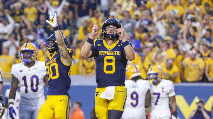 Sep 13, 2025; Morgantown, West Virginia, USA; West Virginia Mountaineers quarterback Nicco Marchiol (8) celebrates after throwing a pass for a touchdown during the fourth quarter against the Pittsburgh Panthers at Milan Puskar Stadium. Mandatory Credit: Ben Queen-Imagn Images