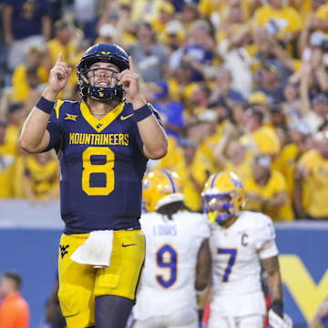 Sep 13, 2025; Morgantown, West Virginia, USA; West Virginia Mountaineers quarterback Nicco Marchiol (8) celebrates after throwing a pass for a touchdown during the fourth quarter against the Pittsburgh Panthers at Milan Puskar Stadium. Mandatory Credit: Ben Queen-Imagn Images