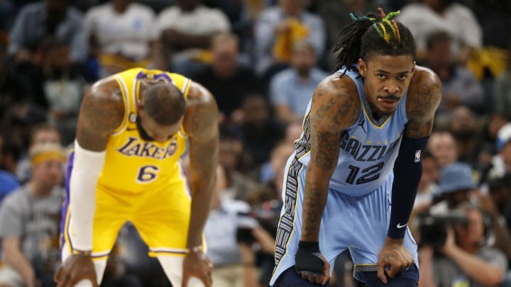 Apr 26, 2023; Memphis, Tennessee, USA; Los Angeles Lakers forward LeBron James (left) and Memphis Grizzlies guard Ja Morant (right) rest during the second half during game five of the 2023 NBA playoffs at FedExForum. 