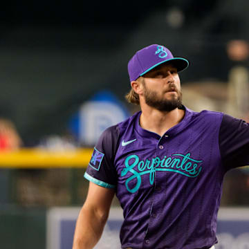 Aug 8, 2025; Phoenix, Arizona, USA; Arizona Diamondbacks pitcher Kendall Graveman (49) reaches out to catch a ball while on the mound to pitch in the eighth inning against the Colorado Rockies at Chase Field. Mandatory Credit: Allan Henry-Imagn Images