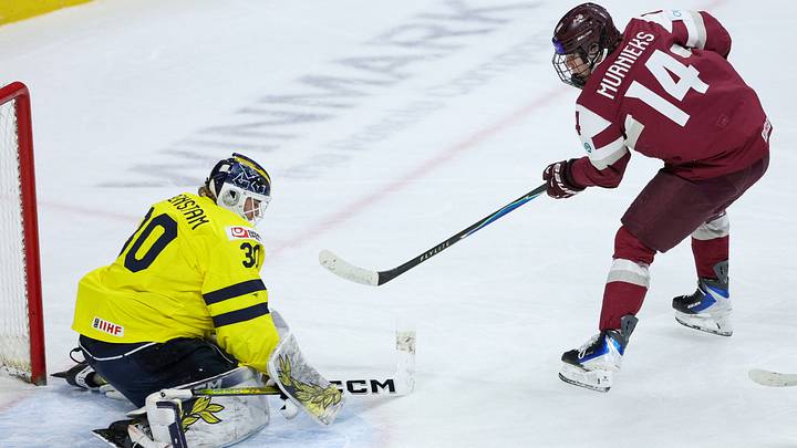 Jan 2, 2026; St. Paul, Minnesota, UNITED STATES; Sweden goalie Love Harenstam (30) defends his net against Latvia forward Olivers Murnieks (14) during the first period in the quarterfinals of the 2026 IIHF World Junior Championship at Grand Casino Arena. Mandatory Credit: Matt Krohn-Imagn Images