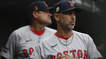 Boston Red Sox manager Alex Cora (13) stands beside first base coach Andy Fox (81) in the dugout at Camden Yards.