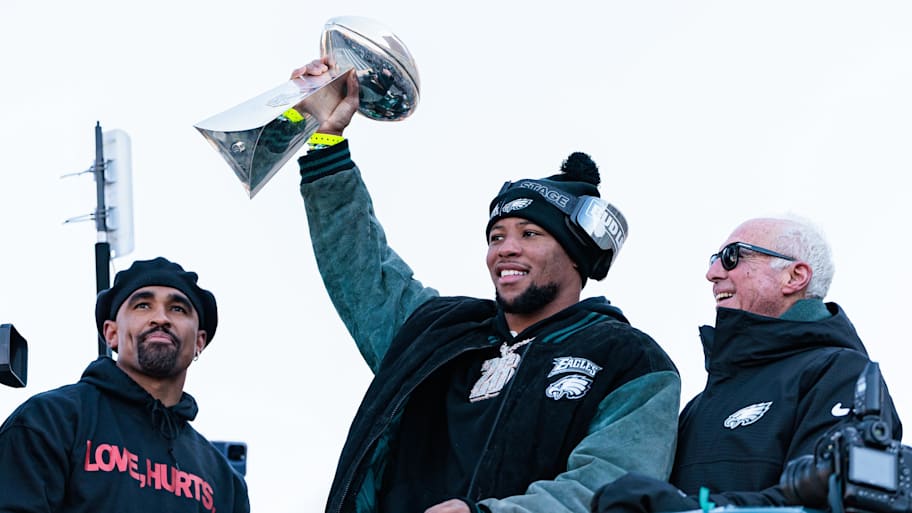 Philadelphia Eagles running back Saquon Barkley lifts the Lombardi Trophy during the Super Bowl LIX championship parade. | Caean Couto-Imagn Images
