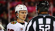 Nov 7, 2025; Calgary, Alberta, CAN; Chicago Blackhawks center Connor Bedard (98) exchanges words with linesman Shandor Alphonso (52) during the second period at Scotiabank Saddledome. Mandatory Credit: Sergei Belski-Imagn Images