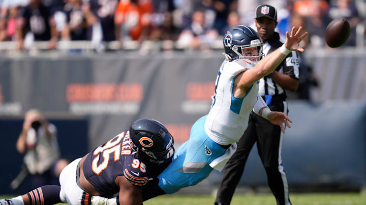 Tennessee Titans quarterback Will Levis (8) flips the ball to avoid a sack by Chicago Bears defensive end DeMarcus Walker (95) but wound up with an interception during the fourth quarter at Soldier Field in Chicago, Ill., Sunday, Sept. 8, 2024.