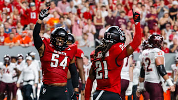 Sep 27, 2025; Raleigh, North Carolina, USA;  North Carolina State Wolfpack defensive end Sabastian Harsh (54) and North Carolina State Wolfpack cornerback Jamel Johnson (21) celebrate during the first half of the game against Virginia Tech Hokies at Carter-Finley Stadium. Mandatory Credit: Jaylynn Nash-Imagn Images