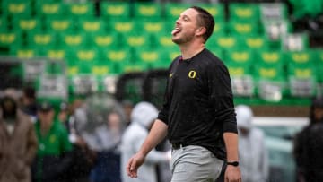 Oregon head coach Dan Lanning sticks his tongue out to catch the rain.
