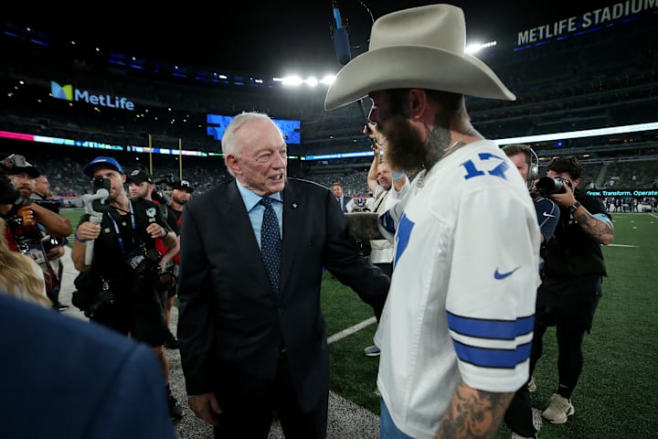 Dallas Cowboys owner Jerry Jones greets recording artist Post Malone on the field before a game against the New York Giants.