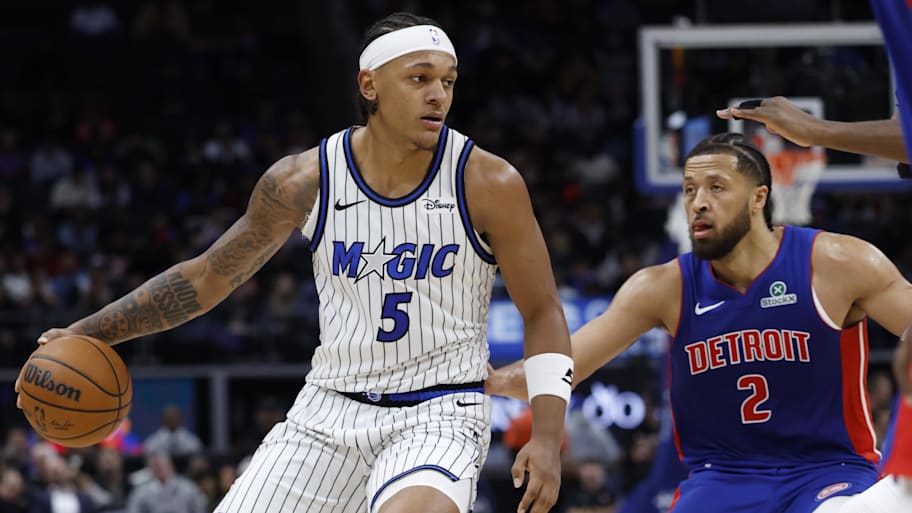 Magic forward Paolo Banchero dribbles while defended by Pistons guard Cade Cunningham.