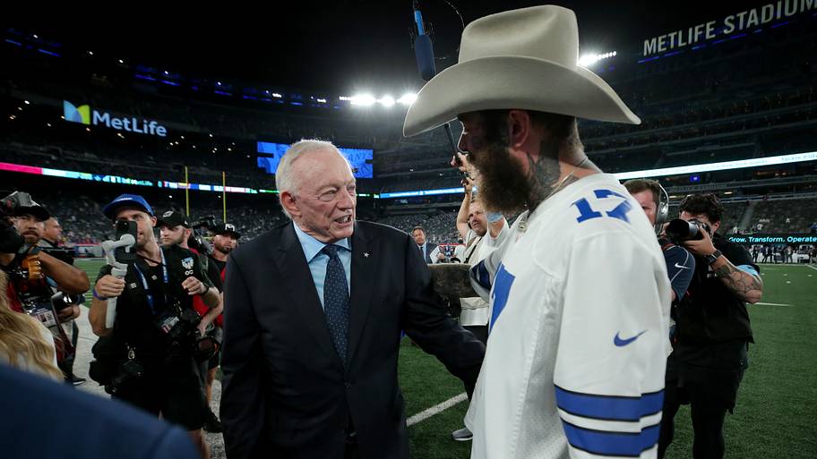 Dallas Cowboys owner Jerry Jones greets recording artist Post Malone on the field before a game against the New York Giants.