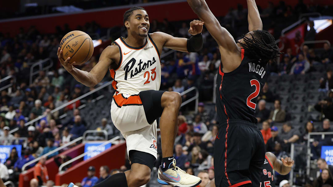 Nov 25, 2024; Detroit, Michigan, USA;  Detroit Pistons guard Jaden Ivey (23) shoots on Toronto Raptors forward Jonathan Mogbo (2) in the first half at Little Caesars Arena. Mandatory Credit: Rick Osentoski-Imagn Images