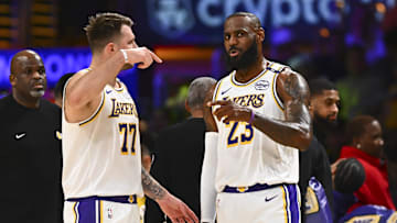 Mar 22, 2025; Los Angeles, California, USA; Los Angeles Lakers guard Luka Doncic (77) and Los Angeles Lakers forward LeBron James (23) on the sidelines against the Chicago Bulls during the first half at Crypto.com Arena. Mandatory Credit: Jonathan Hui-Imagn Images