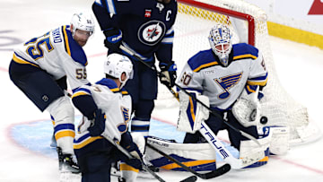 May 4, 2025; Winnipeg, Manitoba, CAN; St. Louis Blues goaltender Jordan Binnington (50) makes a save as Winnipeg Jets center Adam Lowry (17) looks for a rebound in the first overtime in game seven of the first round of the 2025 Stanley Cup Playoffs at Canada Life Centre. Mandatory Credit: James Carey Lauder-Imagn Images