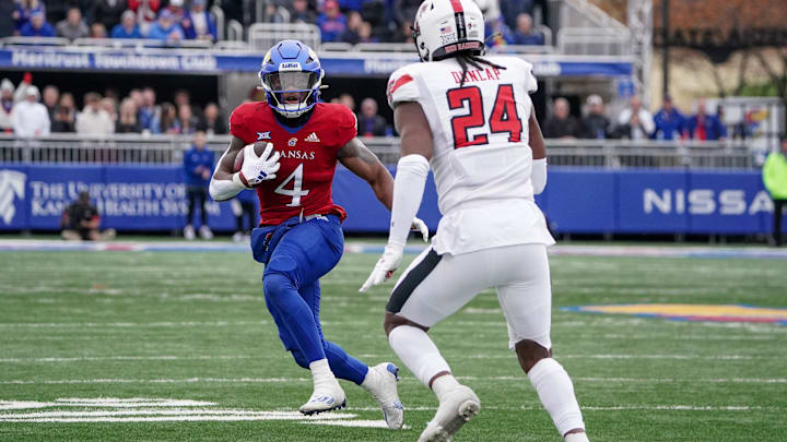 Nov 11, 2023; Lawrence, Kansas, USA; Kansas Jayhawks running back Devin Neal (4) runs the ball against Texas Tech Red Raiders defensive back Malik Dunlap (24) during the second half at David Booth Kansas Memorial Stadium. Mandatory Credit: Denny Medley-Imagn Images