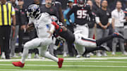 Sep 28, 2025; Houston, Texas, USA; Tennessee Titans quarterback Cam Ward (1) runs with the ball as at Houston Texans linebacker Azeez Al-Shaair (0) attempts to make a tackle during the fourth quarter NRG Stadium. Mandatory Credit: Troy Taormina-Imagn Images