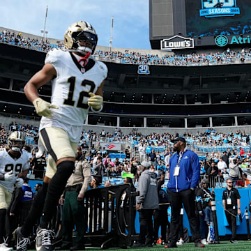 Nov 3, 2024; Charlotte, North Carolina, USA; New Orleans Saints wide receiver Chris Olave (12) runs on to the field before the game at Bank of America Stadium. Mandatory Credit: Bob Donnan-Imagn Images