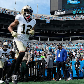 Nov 3, 2024; Charlotte, North Carolina, USA; New Orleans Saints wide receiver Chris Olave (12) runs on to the field before the game at Bank of America Stadium. Mandatory Credit: Bob Donnan-Imagn Images
