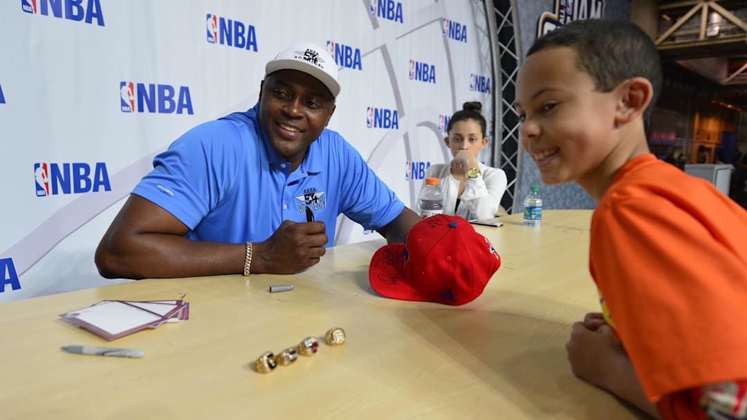Feb 15, 2014; New Orleans, LA, USA; NBA former player Horace Grant signs on autograph for Tristen Berger, 10, of New Orleans during the NBA All Star Jam Session at the Ernest N. Morial Convention Center. Mandatory Credit: Bob Donnan-Imagn Images