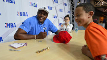 Feb 15, 2014; New Orleans, LA, USA; NBA former player Horace Grant signs on autograph for Tristen Berger, 10, of New Orleans during the NBA All Star Jam Session at the Ernest N. Morial Convention Center. Mandatory Credit: Bob Donnan-Imagn Images