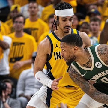 Milwaukee Bucks guard Damian Lillard (0) holds the ball while Indiana Pacers guard Andrew Nembhard (2) defends during game six of the first round for the 2024 NBA playoffs at Gainbridge Fieldhouse.