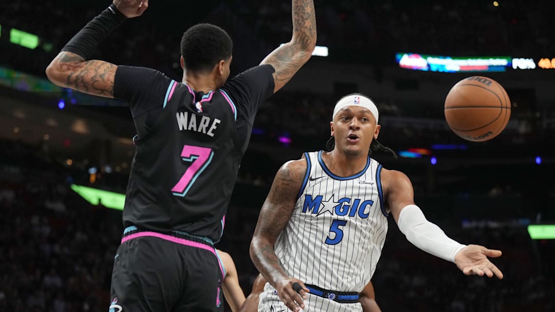Mar 14, 2026; Miami, Florida, USA;  Orlando Magic forward Paolo Banchero (5) passes the ball as he drives to the basket as Miami Heat center Kel'el Ware (7) defends during the first half at Kaseya Center. Mandatory Credit: Jim Rassol-Imagn Images