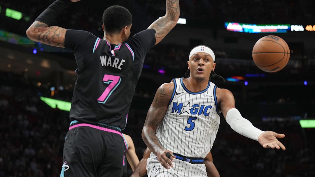 Mar 14, 2026; Miami, Florida, USA;  Orlando Magic forward Paolo Banchero (5) passes the ball as he drives to the basket as Miami Heat center Kel'el Ware (7) defends during the first half at Kaseya Center. Mandatory Credit: Jim Rassol-Imagn Images