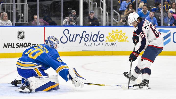 Jan 11, 2025; St. Louis, Missouri, USA;  St. Louis Blues goaltender Jordan Binnington (50) defends the net against Columbus Blue Jackets center Luca Del Bel Belluz (65) during the third period at Enterprise Center. Mandatory Credit: Jeff Curry-Imagn Images