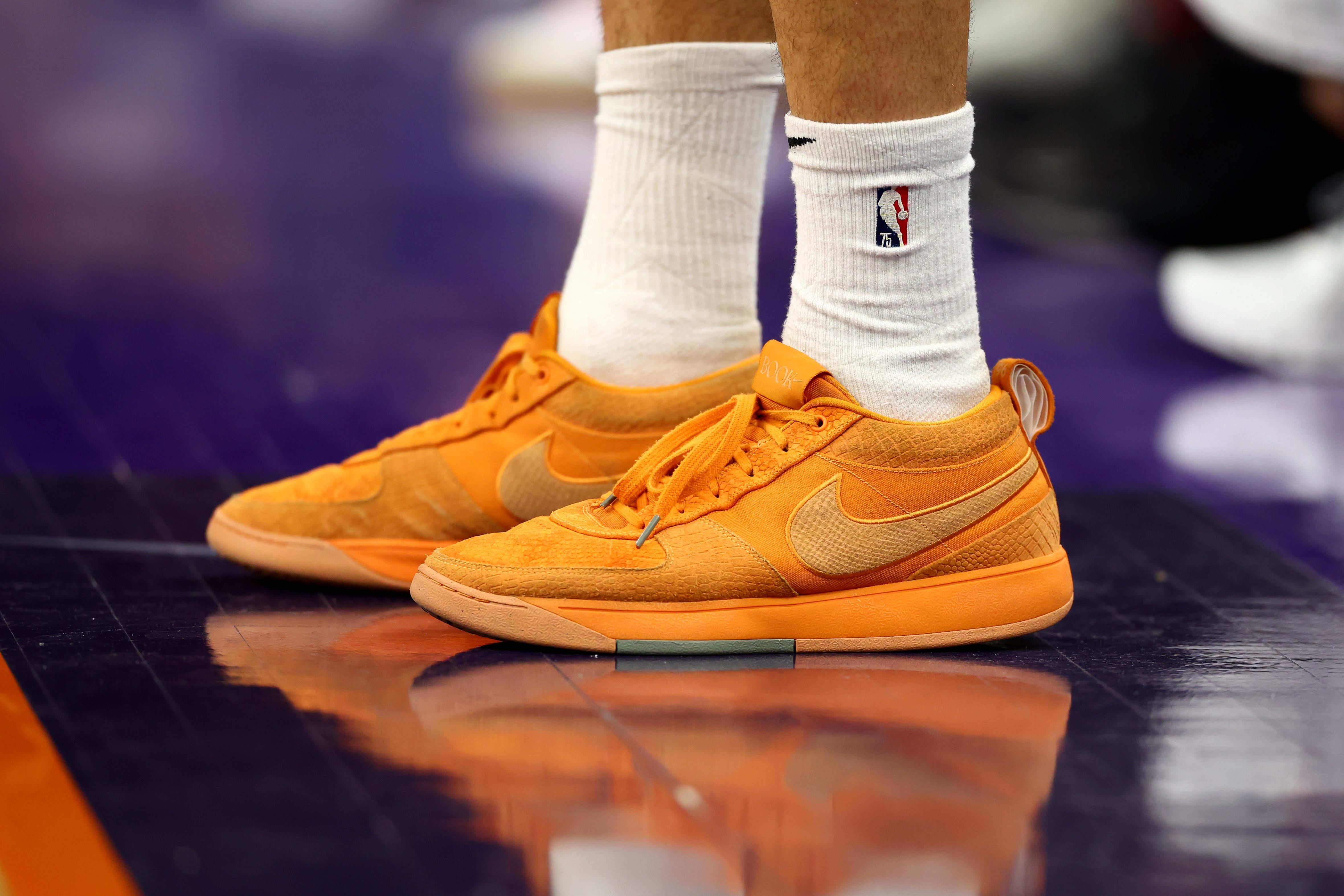 Phoenix Suns guard Devin Booker's orange Nike sneakers.