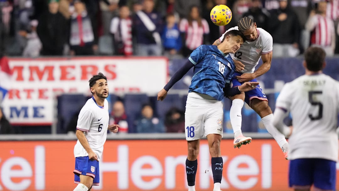 Nov 15, 2025; Chester, Pennsylvania, USA; Paraguay forward Alex Arce (18) and United States defender Miles Robinson (12) jump for a header in the first half at Subaru Park. Mandatory Credit: Kyle Ross-Imagn Images