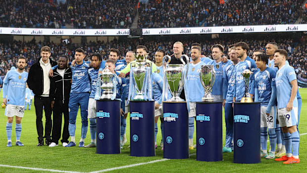 Manchester City versus Sheffield United; Manchester City players pose for a photo with trophies.