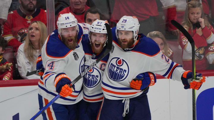 Jun 18, 2024; Sunrise, Florida, USA; Edmonton Oilers forward Connor McDavid (97) celebrates scoring an empty net goal with defenseman Mattias Ekholm (14) and forward Adam Henrique (19) during the third period against the Florida Panthers in game five of the 2024 Stanley Cup Final at Amerant Bank Arena. Mandatory Credit: Jim Rassol-USA TODAY Sports