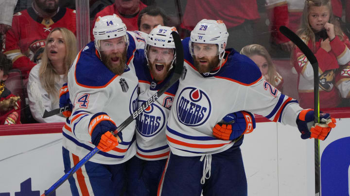Jun 18, 2024; Sunrise, Florida, USA; Edmonton Oilers forward Connor McDavid (97) celebrates scoring an empty net goal with defenseman Mattias Ekholm (14) and forward Adam Henrique (19) during the third period against the Florida Panthers in game five of the 2024 Stanley Cup Final at Amerant Bank Arena. Mandatory Credit: Jim Rassol-USA TODAY Sports
