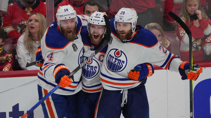 Jun 18, 2024; Sunrise, Florida, USA; Edmonton Oilers forward Connor McDavid (97) celebrates scoring an empty net goal with defenseman Mattias Ekholm (14) and forward Adam Henrique (19) during the third period against the Florida Panthers in game five of the 2024 Stanley Cup Final at Amerant Bank Arena. Mandatory Credit: Jim Rassol-USA TODAY Sports