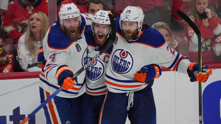 Jun 18, 2024; Sunrise, Florida, USA; Edmonton Oilers forward Connor McDavid (97) celebrates scoring an empty net goal with defenseman Mattias Ekholm (14) and forward Adam Henrique (19) during the third period against the Florida Panthers in game five of the 2024 Stanley Cup Final at Amerant Bank Arena. Mandatory Credit: Jim Rassol-USA TODAY Sports