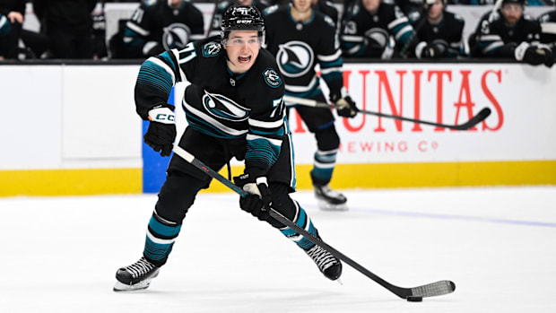 Hockey player in black uniform passes the puc