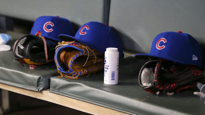 Detailed view of Chicago Cubs hats and gloves in the dugout