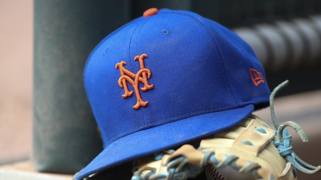 Jul 13, 2022; Atlanta, Georgia, USA; A detailed view of a New York Mets hat and glove in the dugout against the Atlanta Braves in the eighth inning at Truist Park. 
