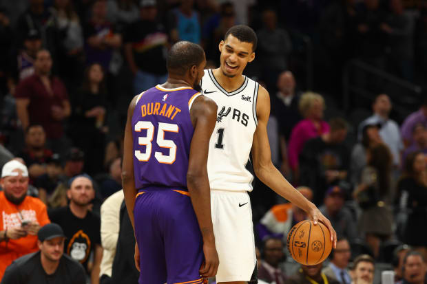 San Antonio Spurs center Victor Wembanyama (1) talks with Phoenix Suns forward Kevin Durant (35). 