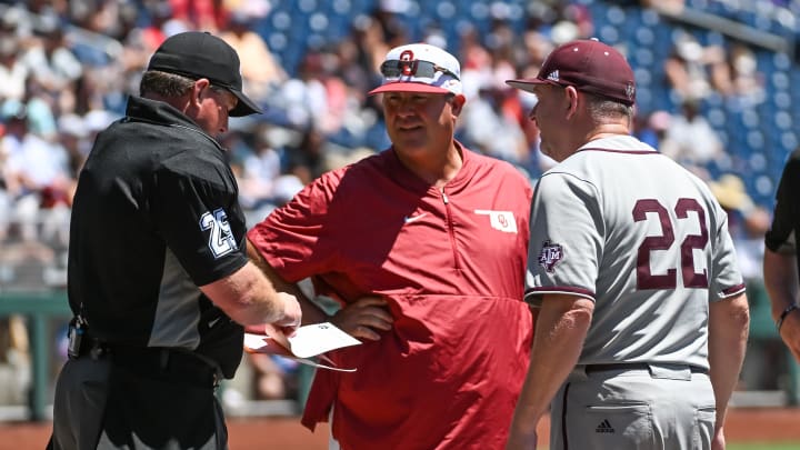 Jun 22, 2022; Omaha, NE, USA; Oklahoma Sooners head coach Skip Johnson and Texas A&M Aggies head coach Jim Schlossnagle talk with the home plate umpire before the game at Charles Schwab Field. Mandatory Credit: Steven Branscombe-USA TODAY Sports
