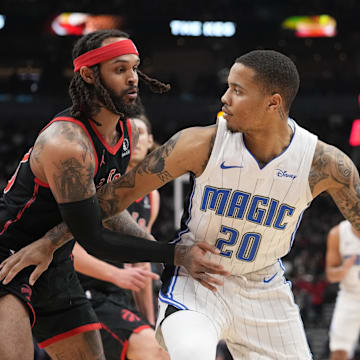 Mar 15, 2024; Toronto, Ontario, CAN; Toronto Raptors guard Gary Trent Jr. (33) defends against Orlando Magic guard Markelle Fultz (20) during the first half at Scotiabank Arena. Mandatory Credit: John E. Sokolowski-Imagn Images