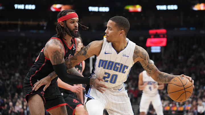 Mar 15, 2024; Toronto, Ontario, CAN; Toronto Raptors guard Gary Trent Jr. (33) defends against Orlando Magic guard Markelle Fultz (20) during the first half at Scotiabank Arena. Mandatory Credit: John E. Sokolowski-Imagn Images