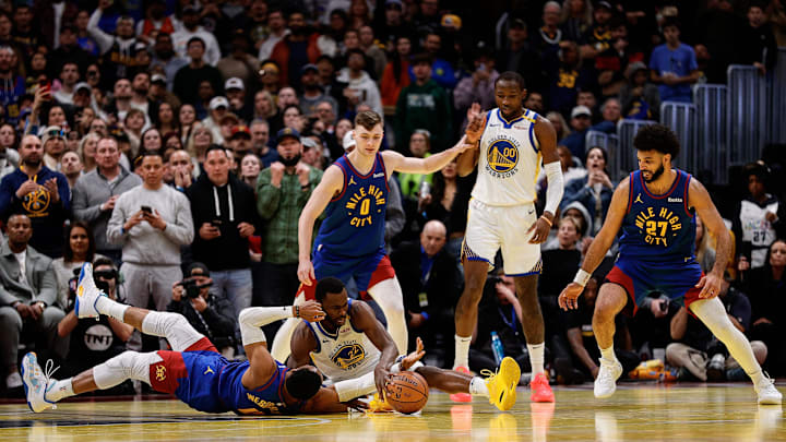 Dec 3, 2024; Denver, Colorado, USA; Golden State Warriors forward Andrew Wiggins (22) battles for for a loose ball with Denver Nuggets guard Russell Westbrook (4) as guard Christian Braun (0) and forward Jonathan Kuminga (00) and guard Jamal Murray (27) look on in the fourth quarter at Ball Arena. Mandatory Credit: Isaiah J. Downing-Imagn Images