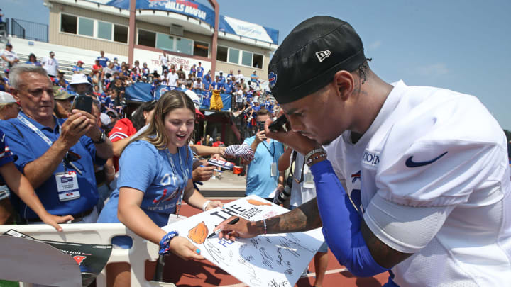 Bills wide receiver Keon Coleman stops to vote for flats as Stephanie Mirras, Seneca Falls, with her father Michael Mirras, and brother James Mirras ask players to vote for their favorite type of chicken wings during the opening day of Buffalo Bills training camp at St. John Fisher Universtiy. The winner, by a landslide, was flats.